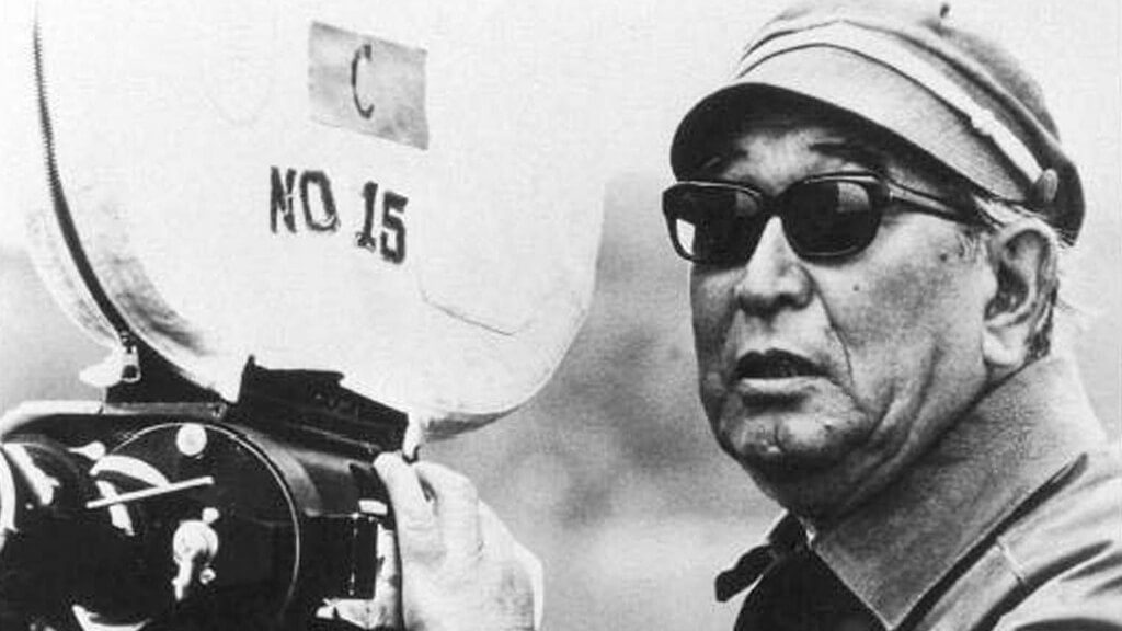 A gray scale image of Akira Kurosawa behind a camera 