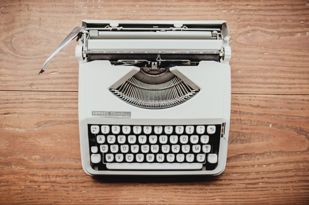 white typewriter on a wooden table