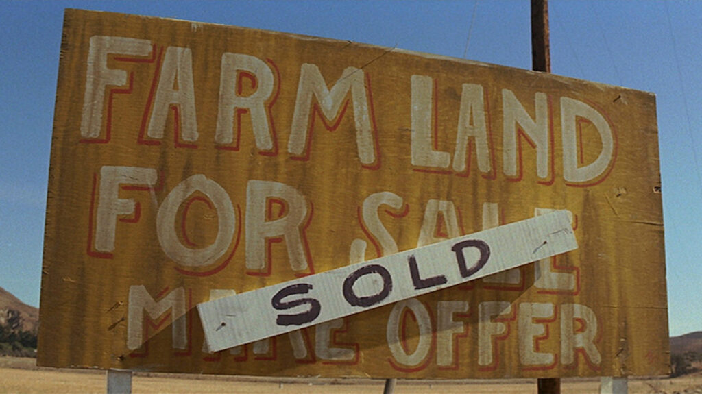 A yellow sign with a sold sign on it in 'Chinatown'