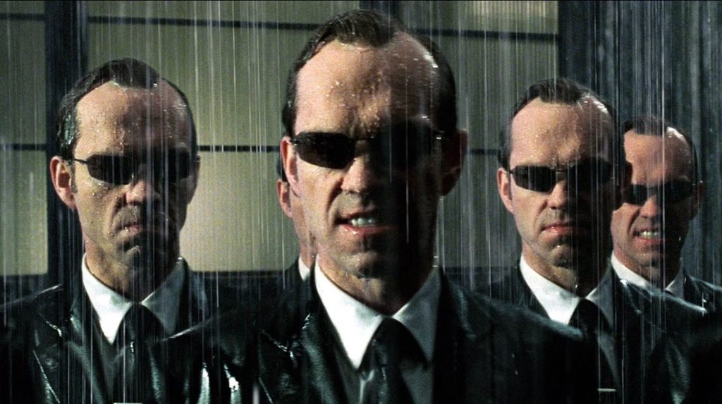 Several Agent Smith (Hugo Weaving) standing in the rain in 'The Matrix'
