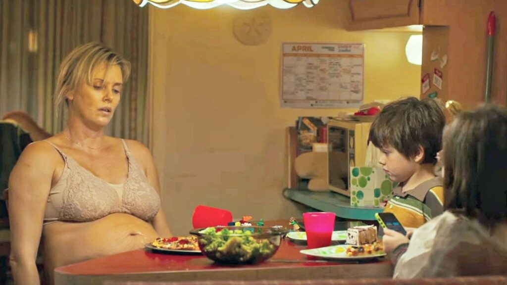 Marlo (Charlize Theron) sitting at a table in her bra in 'Tully,' 5 Trademarks of a Diablo Cody Script