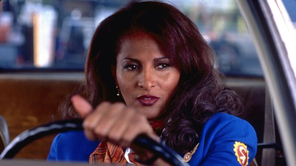 Jackie Brown (Pam Grier) in her airline uniform driving in her car in ‘Jackie Brown,’ '5 Trademarks of Quentin Tarantino Movies'