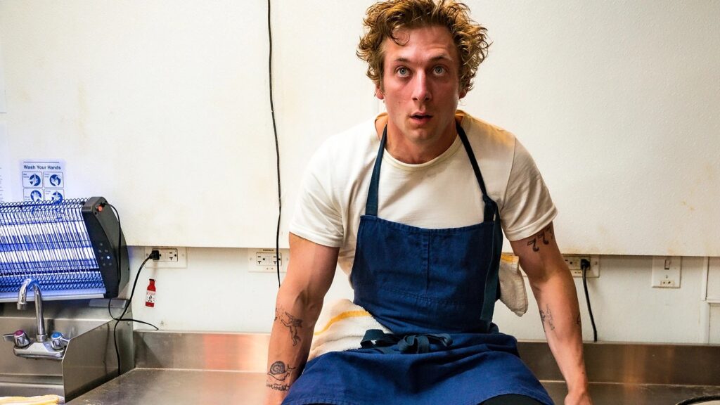 Carmy (Jeremy Allen White) siting on a prep table in 'The Bear' 