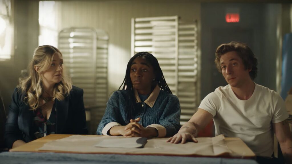 (L-R) Sugar (Abby Elliott), Sydney (Ayo Edebiri), and Carmy (Jeremy Allen White) sitting a table, interview people in 'The Bear'