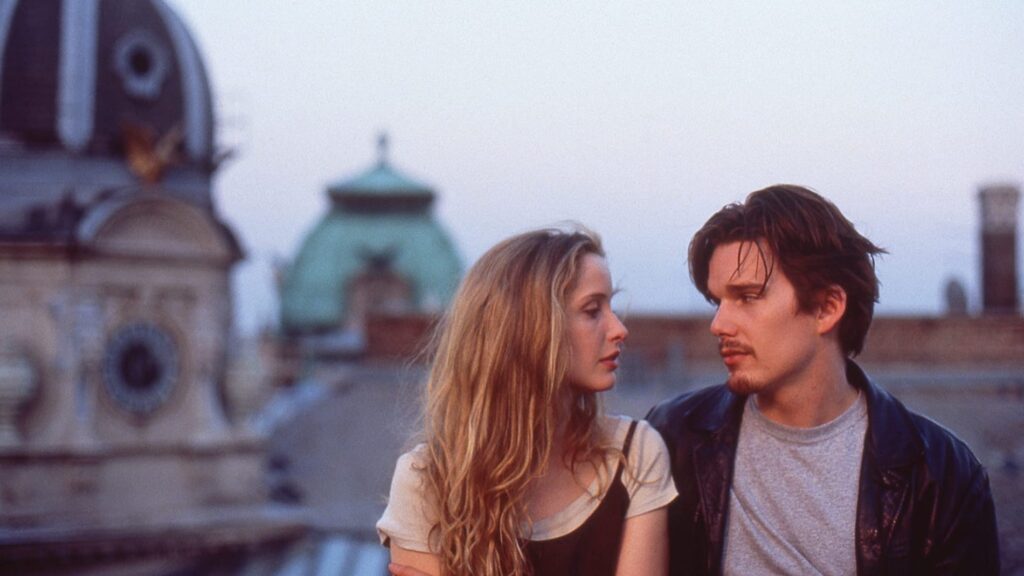 Céline (Julie Delpy) and Jesse (Ethan Hawke) looking at each other on a roof top in 'Before Sunrise,' 100 Meet-Cute Scenarios to Spark Your Screenplay's Romance
