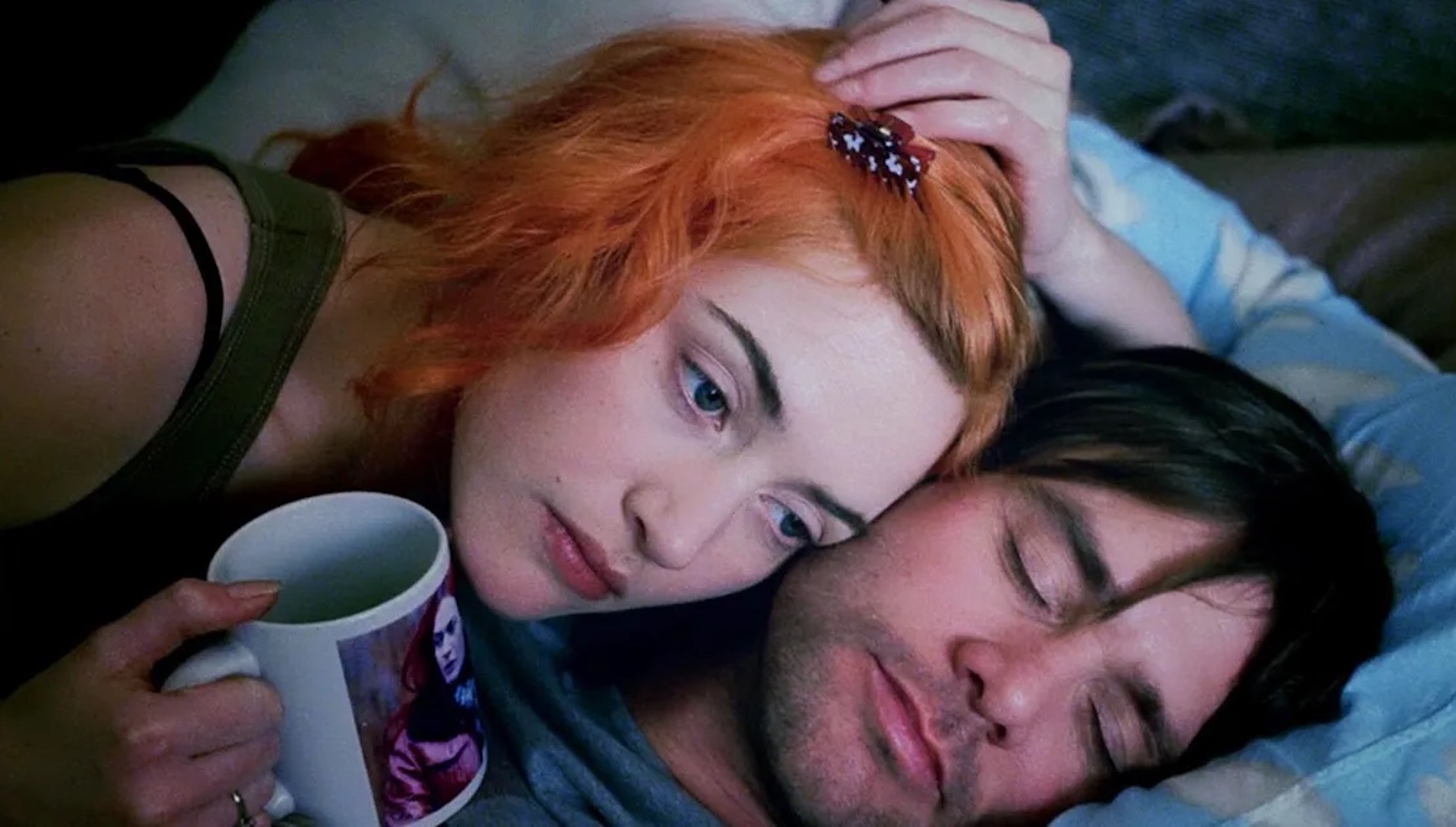 Clementine (Kate Winslet) with orange hair laying on top of Joel (Jim Carrey) in 'Eternal Sunshine of the Spotless Mind'