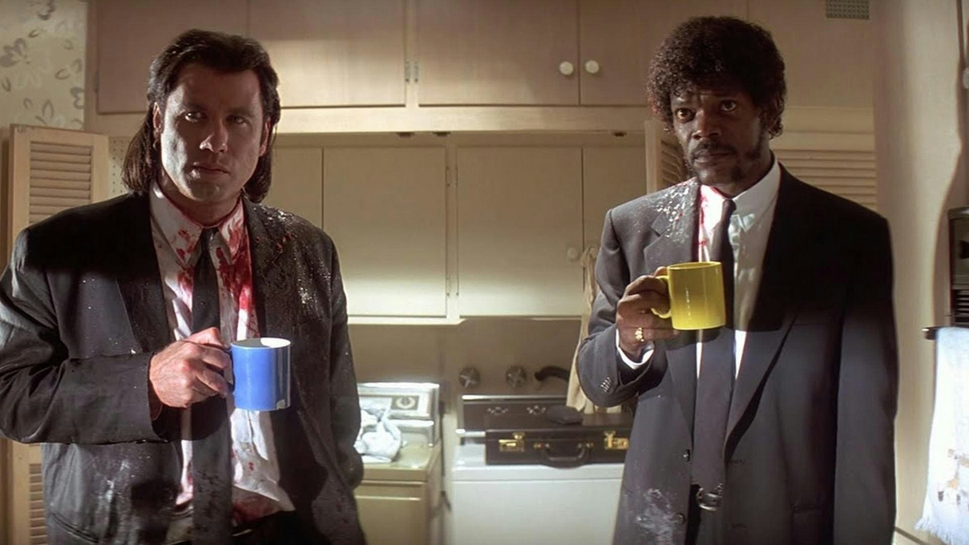 Vincent Vega (John Travolta) and Jules Winnfield (Samuel L. Jackson) drinking coffee while covered in blood in a kitchen in 'Pulp Fiction'