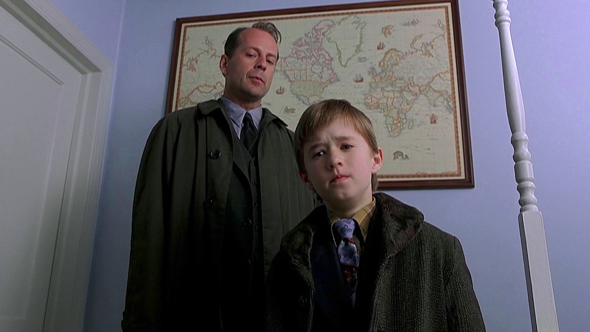 Malcolm Crowe (Bruce Willis) and Cole Sear (Haley Joel Osment) standing at the foot of a bed in 'The Sixth Sense'