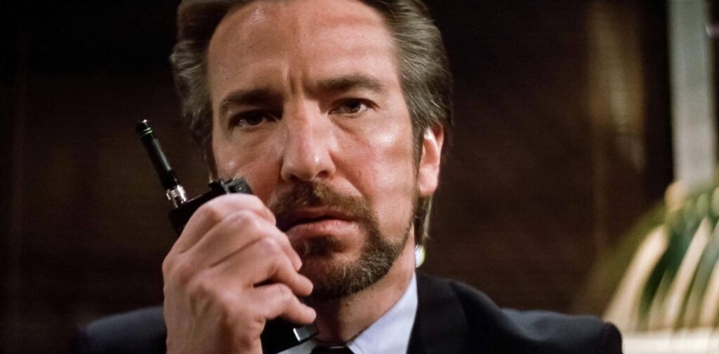 Hans Gruber (Alan Rickman) talking in to a Walkie Talkie in 'Die Hard,' 10 Villain Archetypes Found in Movies and TV