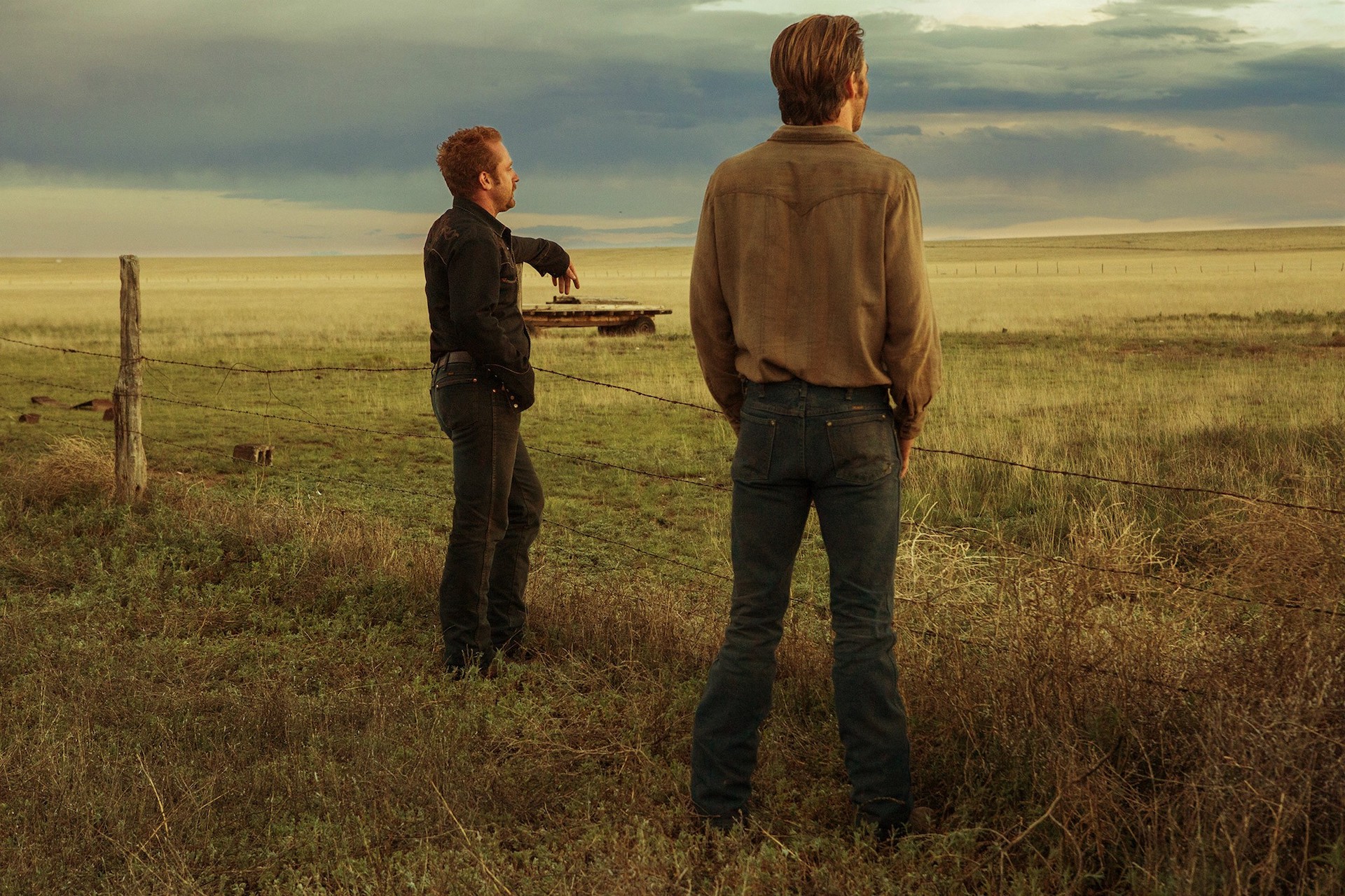 Toby (Chris Pine) and Tanner (Ben Foster) standing next to a field in 'Hell or High Water,' How Taylor Sheridan Redefined the Western Genre With His Own Stories