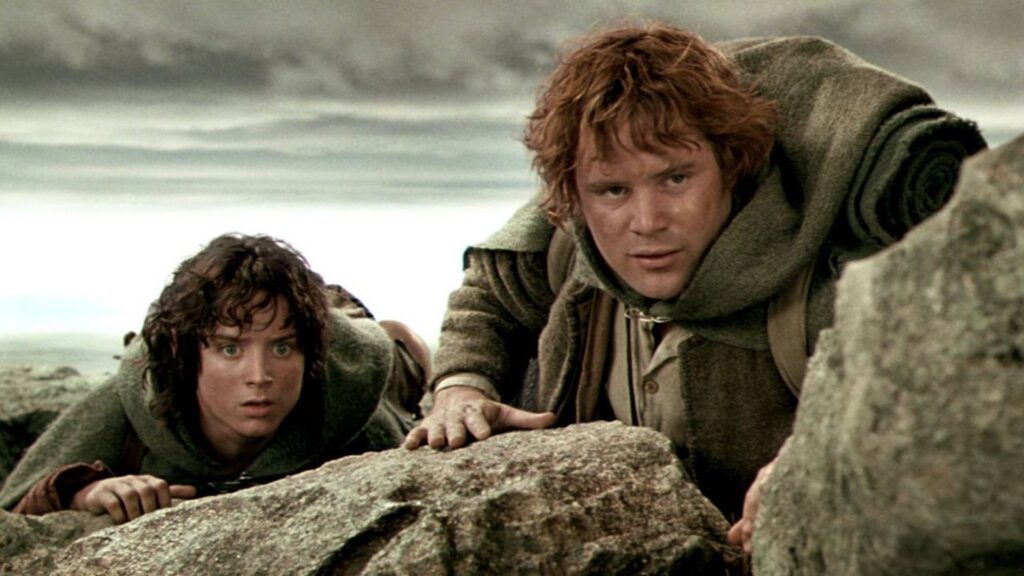 Frodo (Elijah Wood) and Samwise (Sean Astin) looking over rocks in 'The Lord of the Rings: The Two Towers,' 10 Sidekick Character Archetypes in Movies and TV