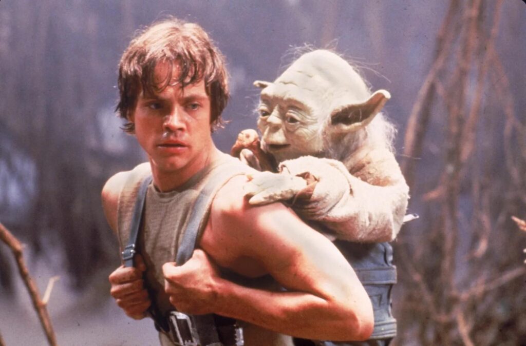 Luke Skywalker (Mark Hamill) carrying Yoda on his back in 'Star Wars: Episode V The Empire Strikes Back,' 100 Epic Journey Story Prompts