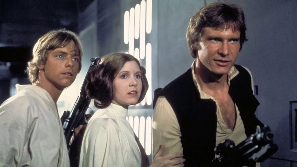 Luke Skywalker (Mark Hamill), Princess Leia (Carrie Fisher), and Han Solo (Harrison Ford) escaping a spaceship in 'Star Wars'