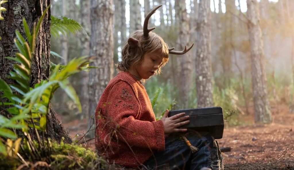 Gus (Christian Convery) opens a box in the woods in 'Sweet Tooth,' 100 Epic Journey Story Prompts