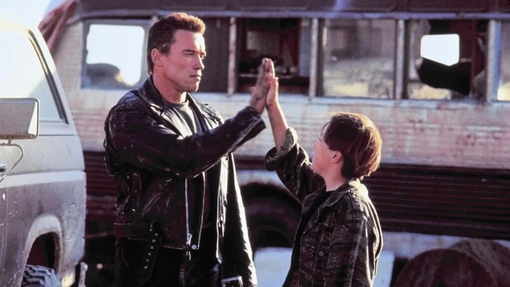 The Terminator (Arnold Schwarzenegger) giving a high five to John Connor (Edward Furlong_ in 'Terminator 2: Judgment Day'