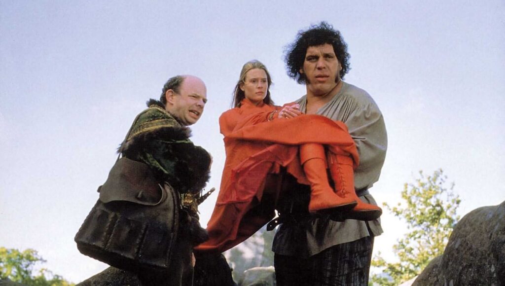 Fezzik (Andre the Giant) holding Princess Buttercup (Robin Wright) in 'The Princess Bride,' 10 Sidekick Character Archetypes in Movies and TV