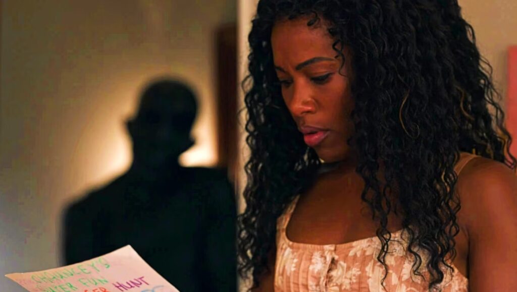 Jessica (DeWanda Wise) reading a note while a shadowy figure watches her in 'Imaginary,' 6 Very Real Screenwriting Lessons from the Writers of 'Imaginary'