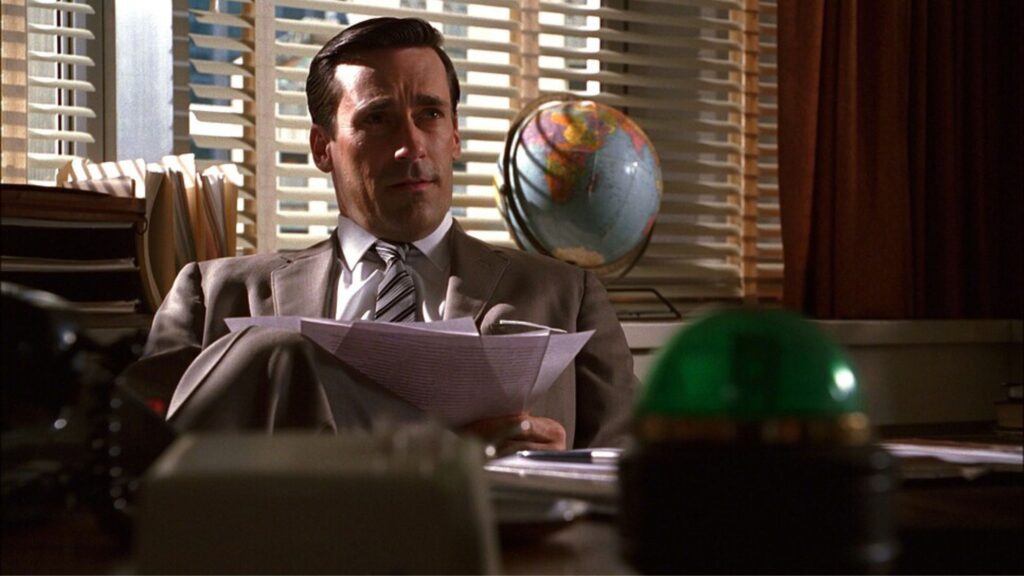 Don (Jon Hamm) reading papers at his desk in 'Mad Men,' This Is Why Your Screenplay's Page Count Matters