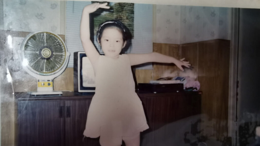 A photograph of Eris Qian has a child dancing in a living room