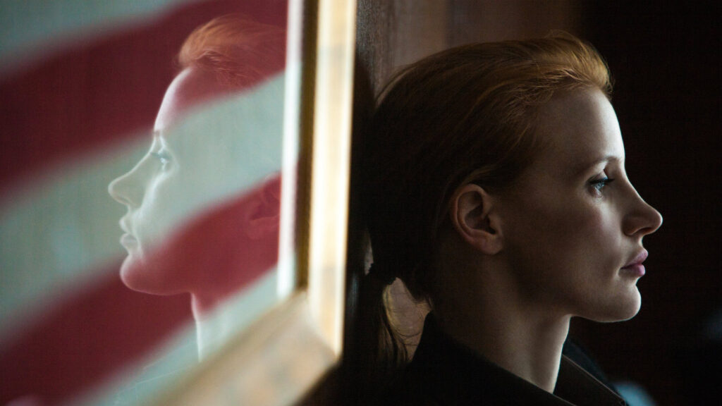 Maya (Jessica Chastain) sitting by a framed American flag in 'Zero Dark Thirty,' 5 Trademarks of Kathryn Bigelow Films