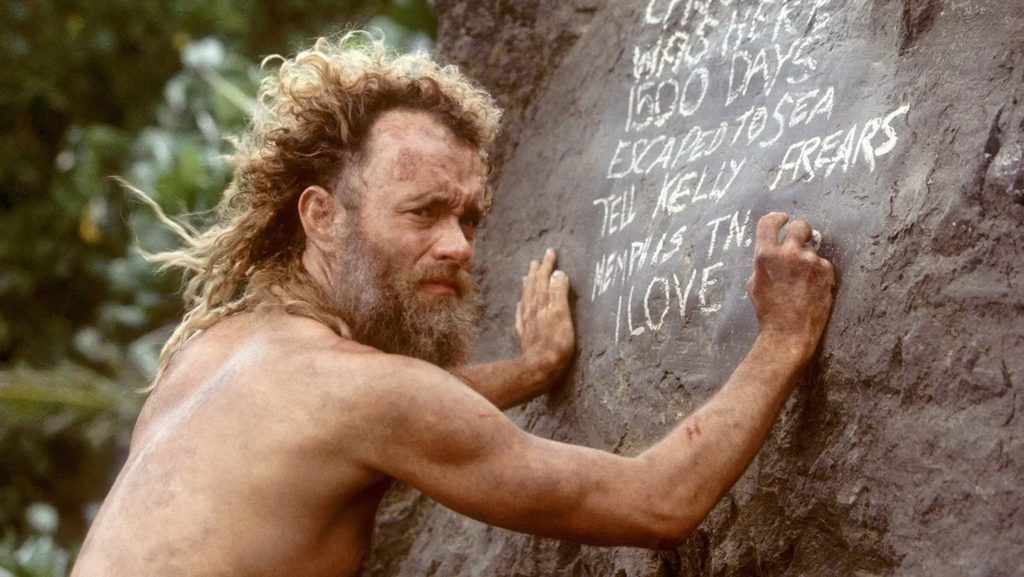 Chuck (Tom Hanks) writing on a rock in 'Cast Away,' 100 Character Vs. Nature Story Prompts