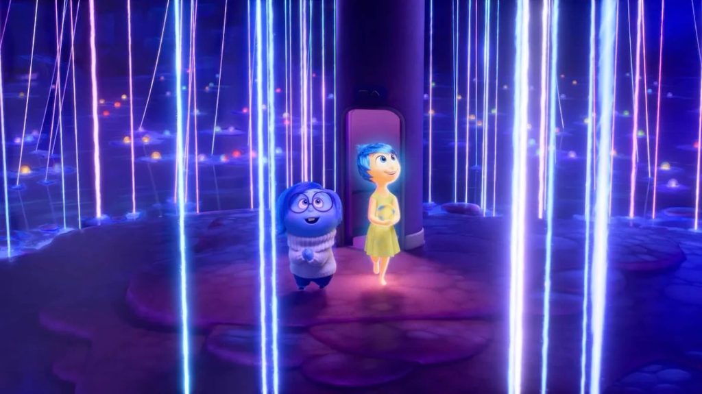 Joy (Amy Poehler) and Sadness (Phyllis Smith) walking through a part of the brain with glowing lines of lights in 'Inside Out 2' 