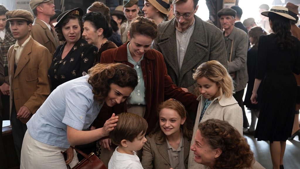 A group of women looking over a young boy in 'We Were The Lucky Ones'