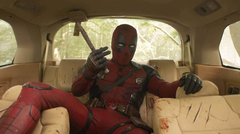 Deadpool (Ryan Reynolds) in the backseat of a torn up car in 'Deadpool & Wolverine'