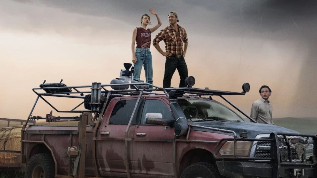 Kate (Daisy Edgar-Jones) and Tyler (Glen Powell) standing on a truck looking up at the weather in 'Twisters'