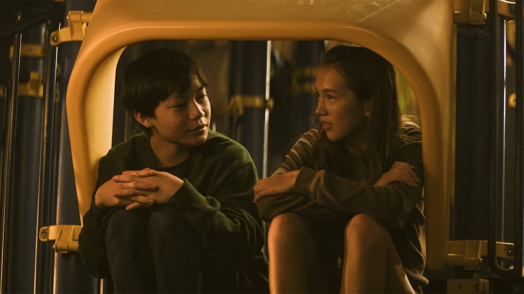 Chris Wang (Izaac Wang) and Madi (Mahaela Park) talking in a playground in 'Didi'