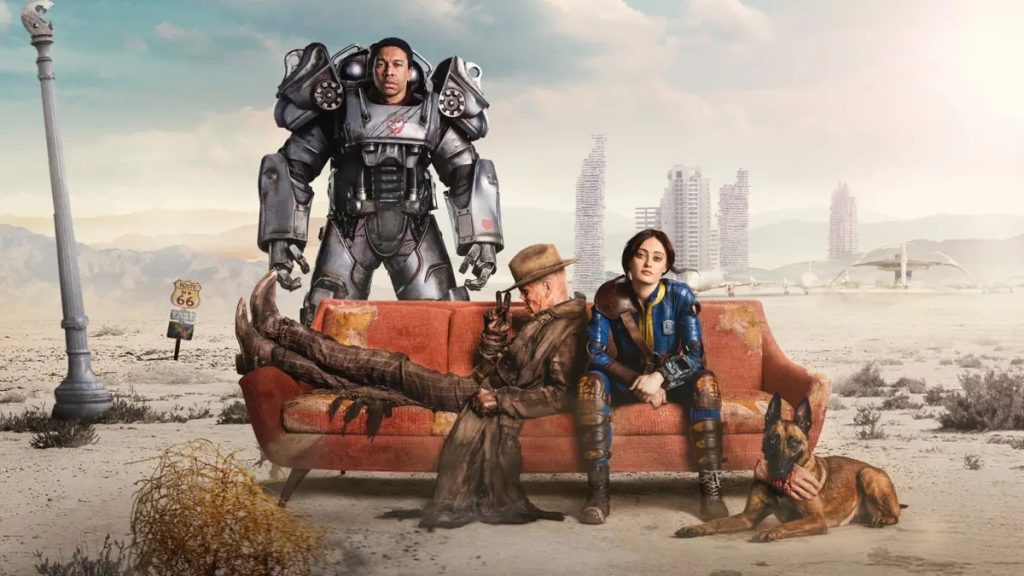 Maximus (Aaron Moten), the Ghoul (Walton Goggins), and Lucy (Ella Purnell) sitting on a red couch in 'Fallout'