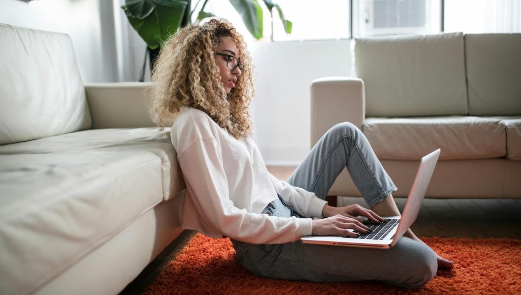 A woman sitting on the ground as she types on a laptop; What Is a Professional Polish Draft in Screenwriting?