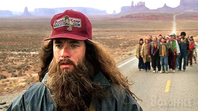 Forrest Gump (Tom Hanks) with a long beard running with a crowd behind him in 'Forrest Gump'