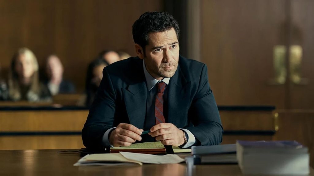 Mickey Haller (Manuel Garcia-Rulfo) sitting at a table in a courtroom in 'The Lincoln Lawyer'