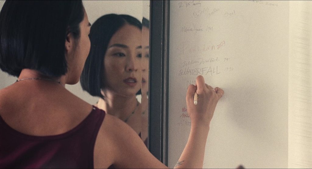 Nora (Greta Lee) writing on the wall in 'Past Lives'