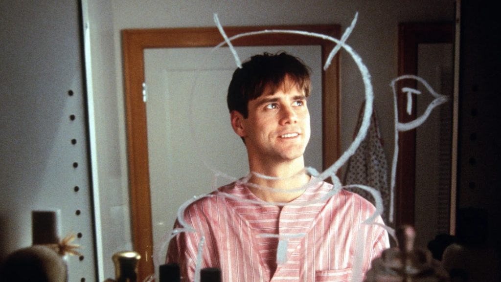 Truman (Jim Carrey) looking into a bathroom mirror with soap drawings around him in 'The Truman Show'