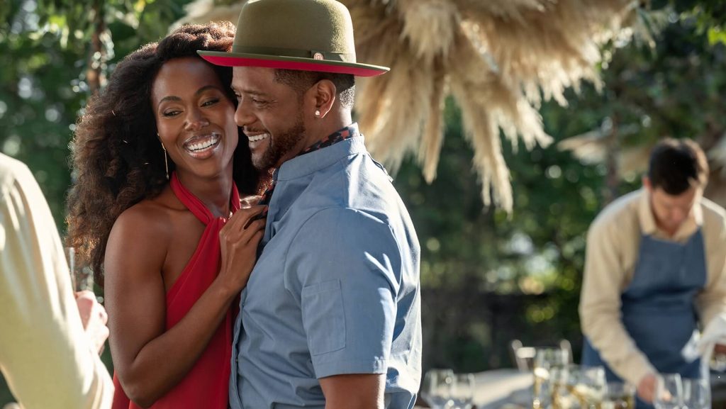 Sloane (DeWanda Wise) and Richard (Blair Underwood) laughing at a dinner party.