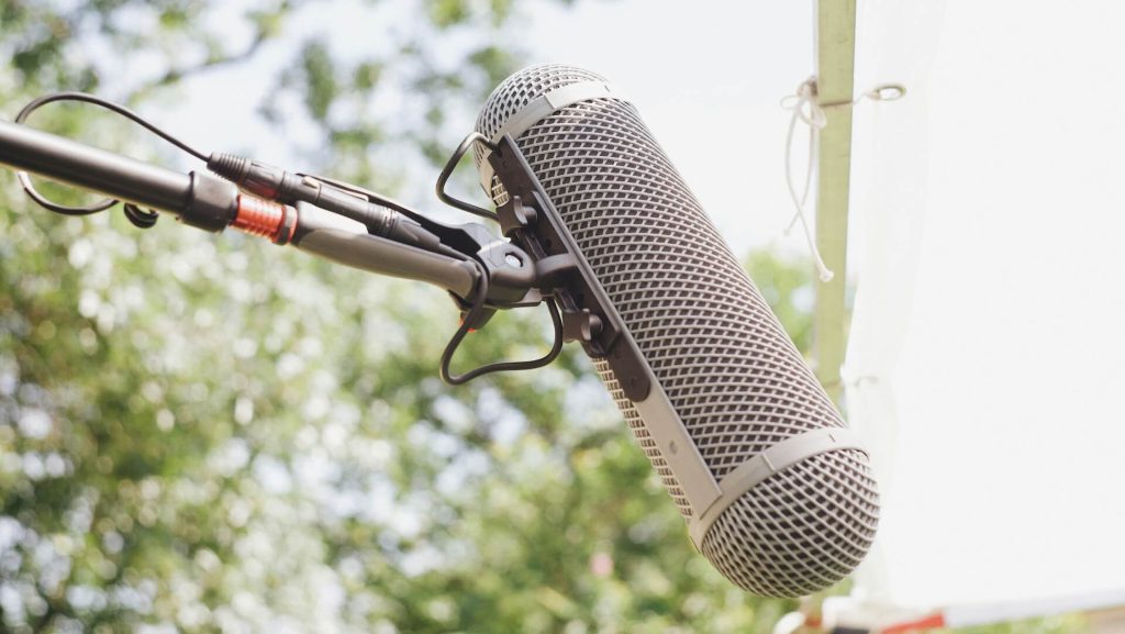 A boom mic on a film set during the day