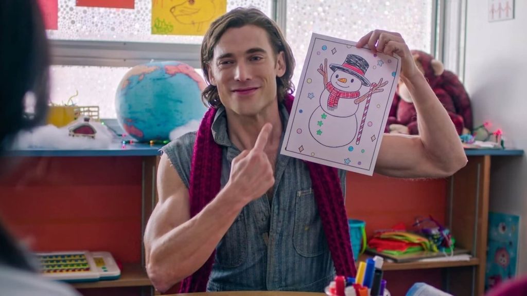 Dustin Milligan plays Jack Snowman, holding a drawing of a snowman and pointing at himself.