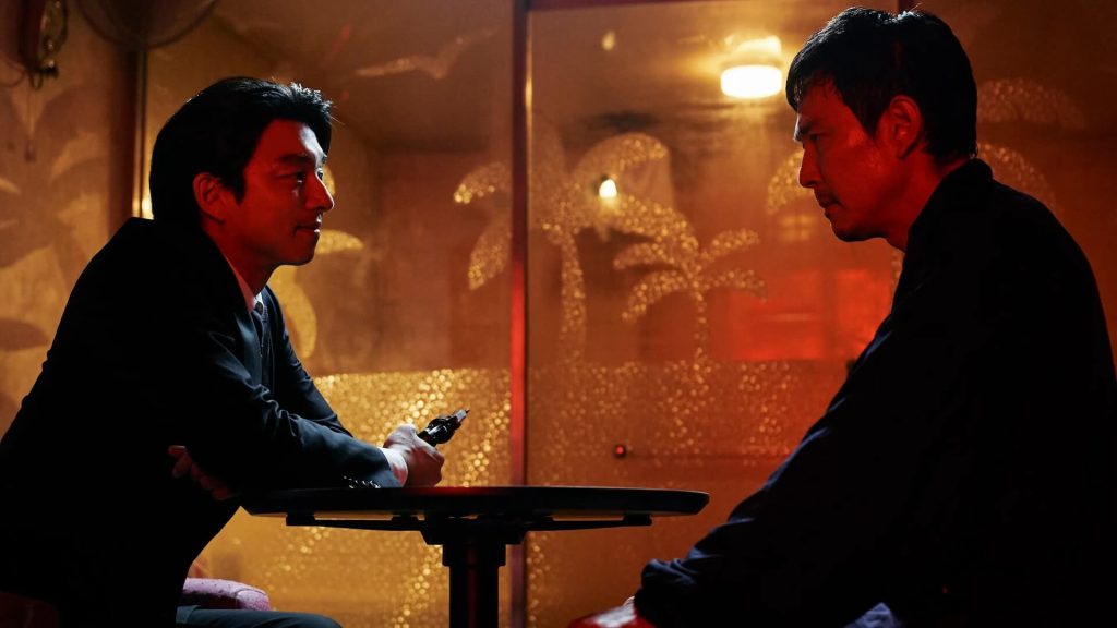 A salesman (played by Gong Yoo) talks to Ki-hoon (played by Lee Jung-jae) at a restaurant.